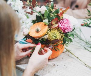Una Influencer de DIY haciendo un florero con plantas y flores de papel y cartón de colores vibrantes.
